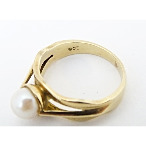 595 - A 9ct gold ring set with central pearl. Ring size approx. L