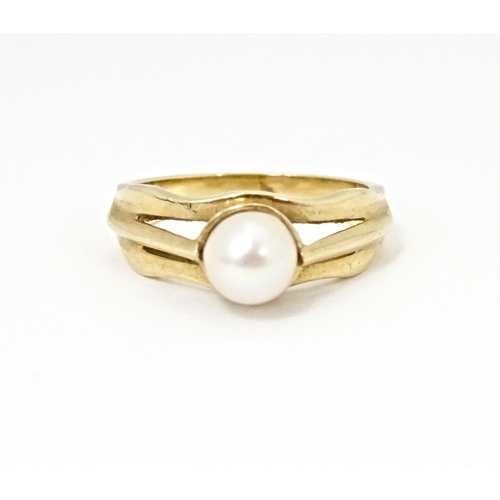 595 - A 9ct gold ring set with central pearl. Ring size approx. L