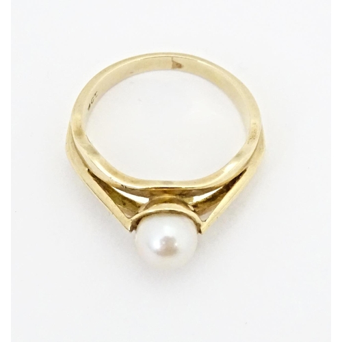 595 - A 9ct gold ring set with central pearl. Ring size approx. L