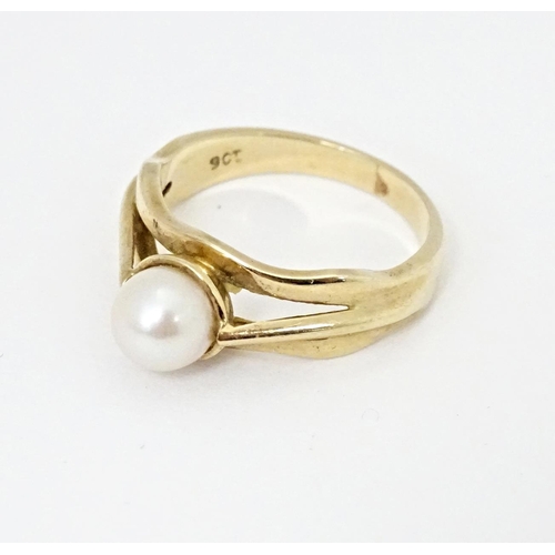 595 - A 9ct gold ring set with central pearl. Ring size approx. L