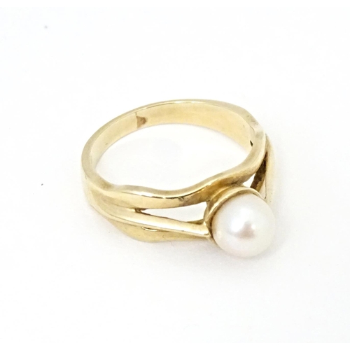 595 - A 9ct gold ring set with central pearl. Ring size approx. L