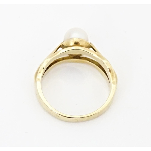 595 - A 9ct gold ring set with central pearl. Ring size approx. L