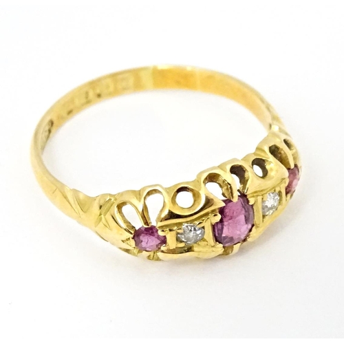 597 - An 18ct gold ring set with three rubies and two diamonds, hallmarked Birmingham 1915. Ring size appr... 