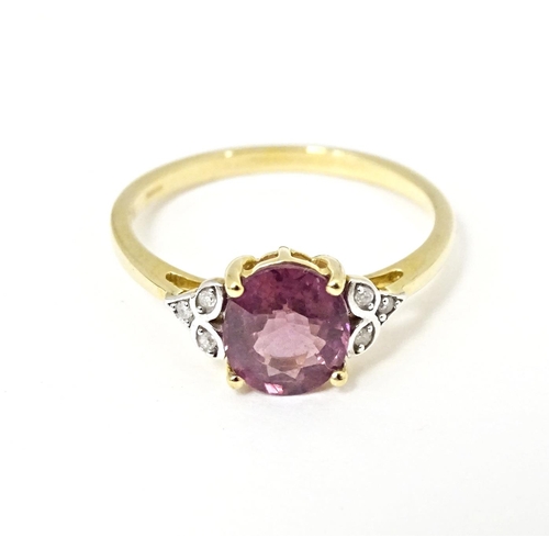 599 - A 9ct gold ring set with central Mangochi garnet flanked by diamonds. Ring size approx. P