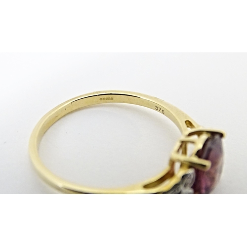 599 - A 9ct gold ring set with central Mangochi garnet flanked by diamonds. Ring size approx. P