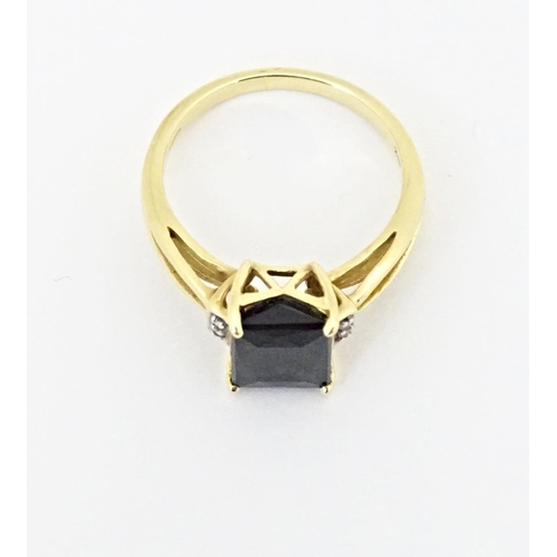 600 - An 18ct gold ring set with central Indicolite tourmaline flanked by diamonds. Ring size approx. M