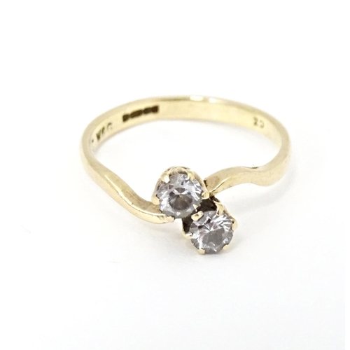 602 - A 9ct gold ring set with two white stones. Ring size approx. N