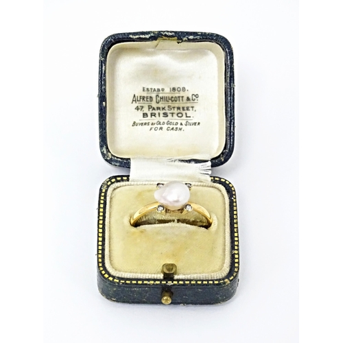 621 - A 22ct gold ring set with central pearl bordered by four diamonds. Ring size approx. S