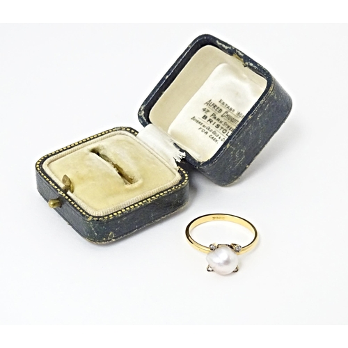 621 - A 22ct gold ring set with central pearl bordered by four diamonds. Ring size approx. S