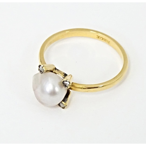 621 - A 22ct gold ring set with central pearl bordered by four diamonds. Ring size approx. S