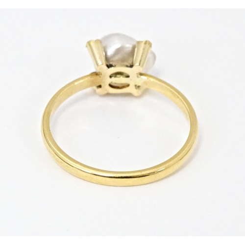 621 - A 22ct gold ring set with central pearl bordered by four diamonds. Ring size approx. S