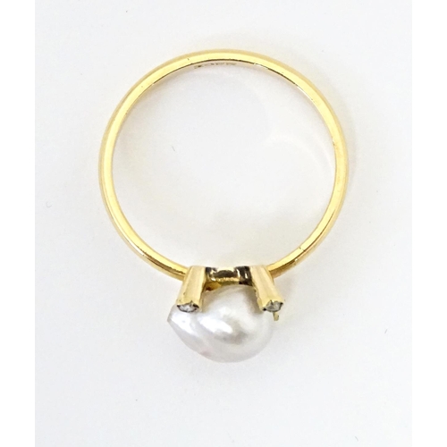 621 - A 22ct gold ring set with central pearl bordered by four diamonds. Ring size approx. S