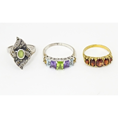 624 - Three silver dress rings comprising silver gilt & garnet, silver & marcasite, and amethyst, aquamari... 