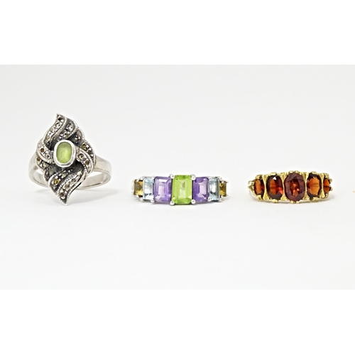 624 - Three silver dress rings comprising silver gilt & garnet, silver & marcasite, and amethyst, aquamari... 