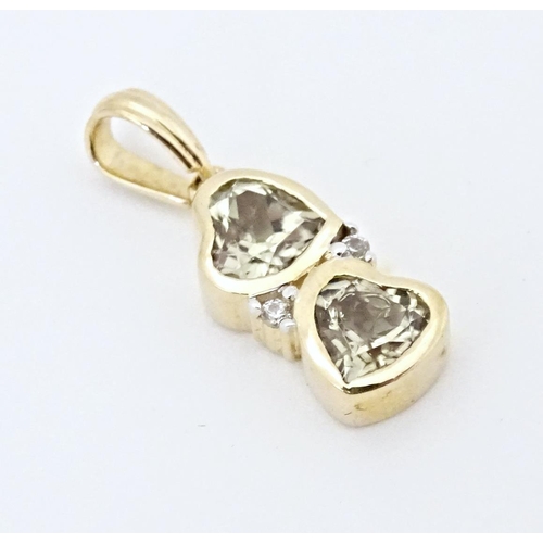 626 - A 9ct gold ring set with two Csarite of heart form flanked by diamonds. Together with a similar pend... 