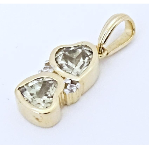 626 - A 9ct gold ring set with two Csarite of heart form flanked by diamonds. Together with a similar pend... 