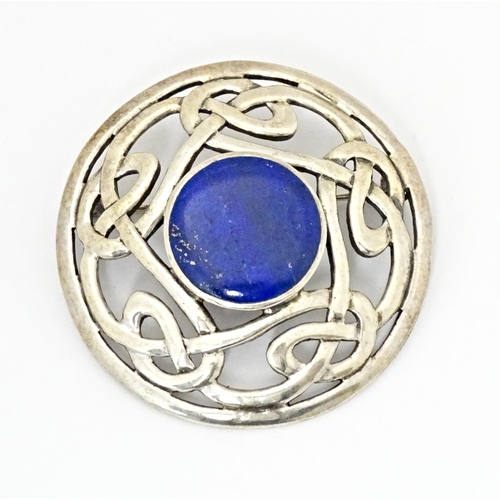 627 - A silver brooch of circular form with Celtic style decoration set central blue cabochon. Approx. 1 3... 