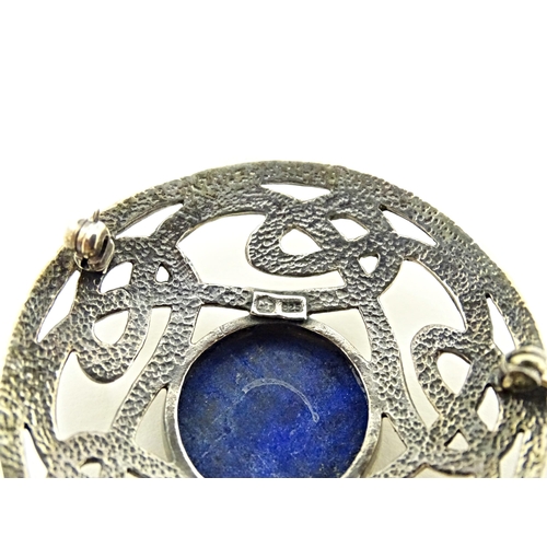 627 - A silver brooch of circular form with Celtic style decoration set central blue cabochon. Approx. 1 3... 