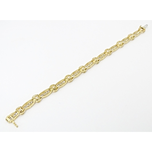 634 - A 9ct gold bracelet set with 50 diamonds interspersed by further bands of diamonds. Marked 10k. Appr... 