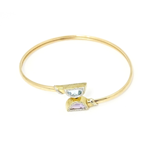 635 - A 9ct gold and yellow metal bracelet of bangle form set with amethyst and topaz.