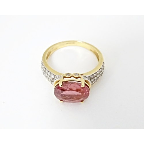 552 - An 18ct gold ring set with central Cruzeiro Rubellite flanked by diamonds to shoulders. Ring size ap... 