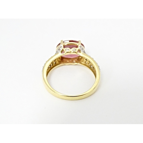 552 - An 18ct gold ring set with central Cruzeiro Rubellite flanked by diamonds to shoulders. Ring size ap... 