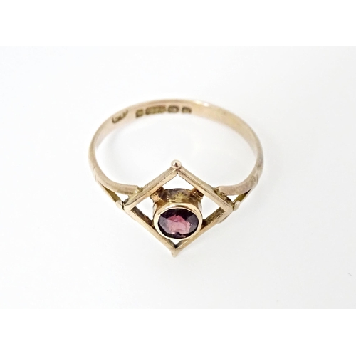 553 - A 9ct gold ring set with central garnet. Ring size approx. N