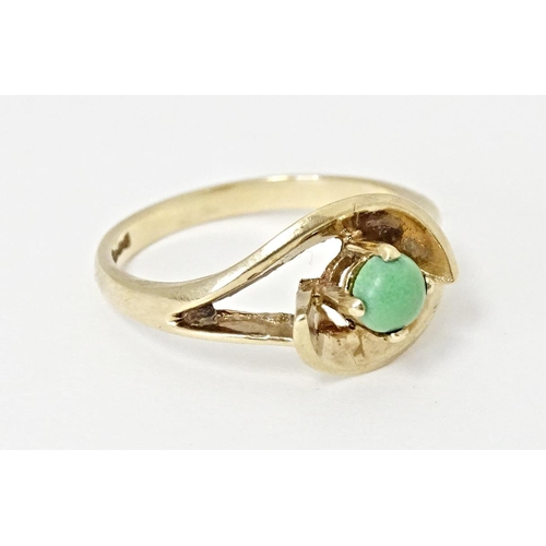 558 - A 9ct gold ring set with central green stone cabochon in an open setting. Ring size approx. O