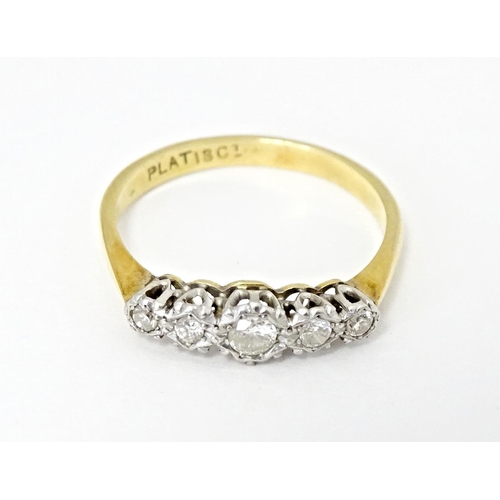 560 - An 18ct gold ring with five graduated diamonds in a platinum setting. Ring size approx. P 1/2