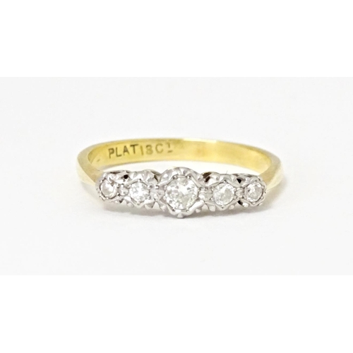 560 - An 18ct gold ring with five graduated diamonds in a platinum setting. Ring size approx. P 1/2