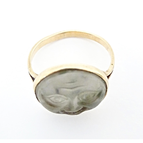 561 - A yellow metal ring set with Man in the Moon cabochon to top. Ring size approx. F 1/2