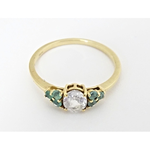 562 - A 9ct gold ring set with central Singida Tanzanian zircon flanked by aquaiba beryl. Ring size approx... 