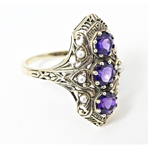 569 - A 9ct gold ring set with amethysts and seed pearls. Ring size approx. O