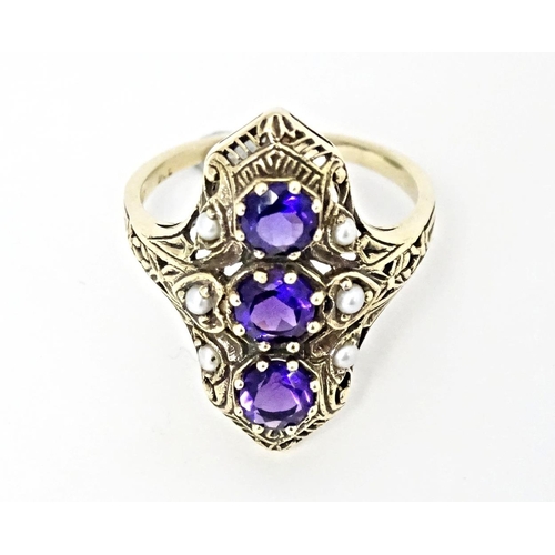 569 - A 9ct gold ring set with amethysts and seed pearls. Ring size approx. O