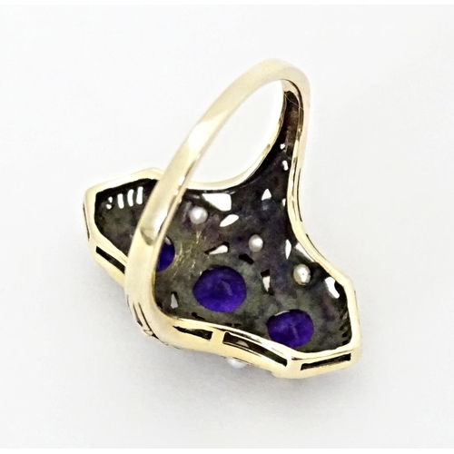 569 - A 9ct gold ring set with amethysts and seed pearls. Ring size approx. O