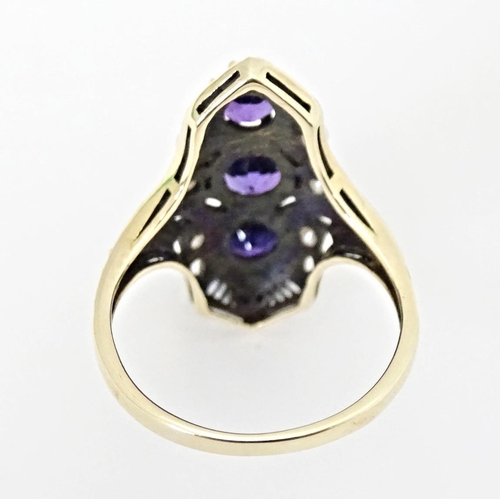 569 - A 9ct gold ring set with amethysts and seed pearls. Ring size approx. O