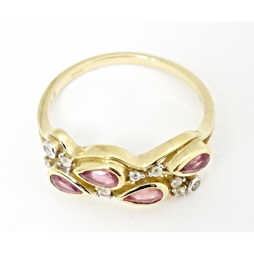 571 - A 9ct gold ring set with Padparadscha sapphire and white zircons. Ring size approx. R