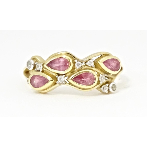 571 - A 9ct gold ring set with Padparadscha sapphire and white zircons. Ring size approx. R