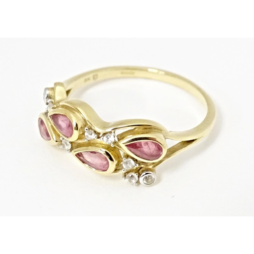 571 - A 9ct gold ring set with Padparadscha sapphire and white zircons. Ring size approx. R