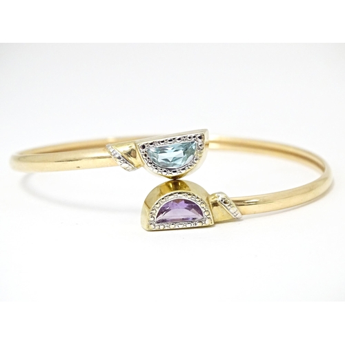 635 - A 9ct gold and yellow metal bracelet of bangle form set with amethyst and topaz.