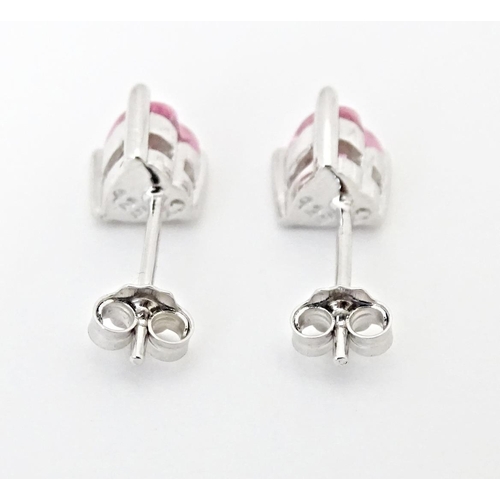 642 - A pair of silver stud earrings set with pink stones of heart.