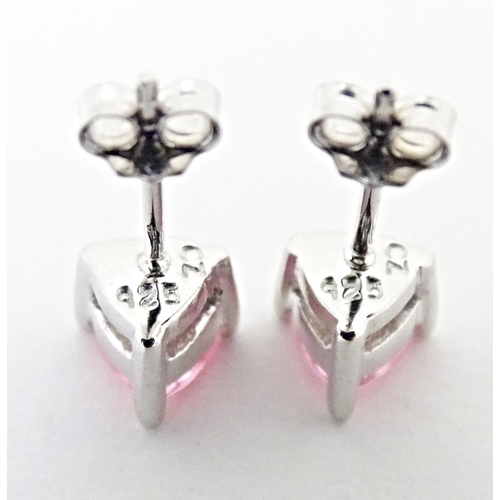 642 - A pair of silver stud earrings set with pink stones of heart.