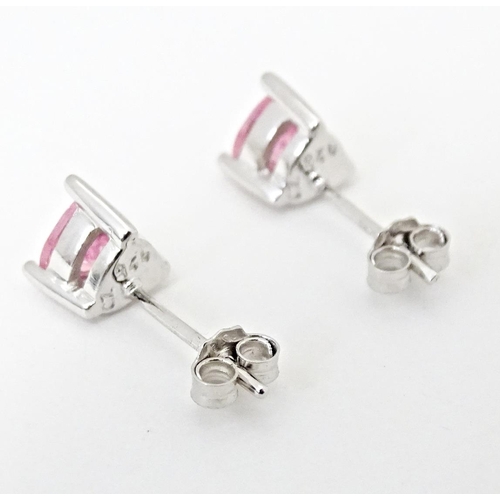 642 - A pair of silver stud earrings set with pink stones of heart.