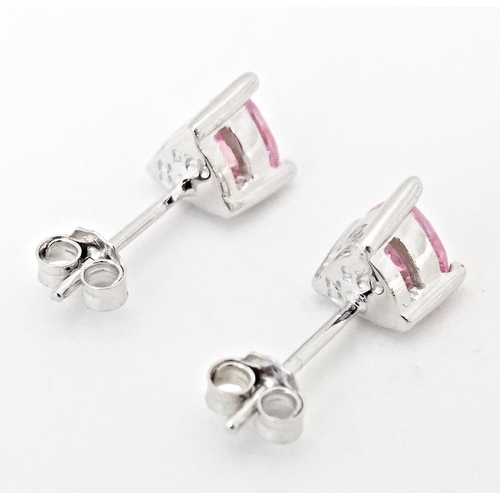 642 - A pair of silver stud earrings set with pink stones of heart.