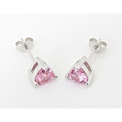 642 - A pair of silver stud earrings set with pink stones of heart.