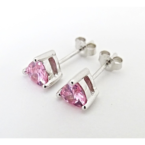 642 - A pair of silver stud earrings set with pink stones of heart.