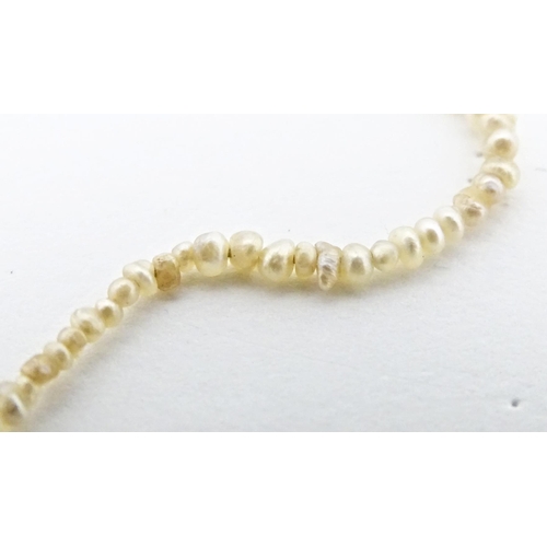 648 - A graduated pearl necklace with yellow metal clasp. Approx. 13 1/2