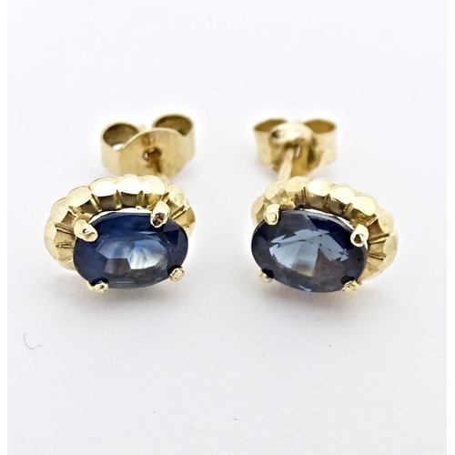 649 - A pair of yellow metal stud earrings set with central sapphire