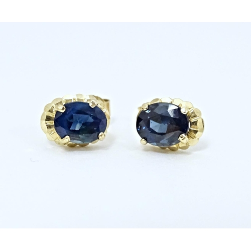 649 - A pair of yellow metal stud earrings set with central sapphire