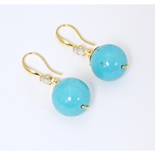 654 - A pair of gilt metal drop earrings set with turquoise coloured beads with white stone detail. Approx... 